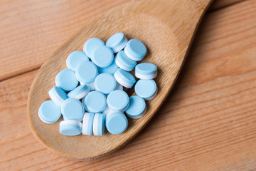 blue medicine pill on wooden table 