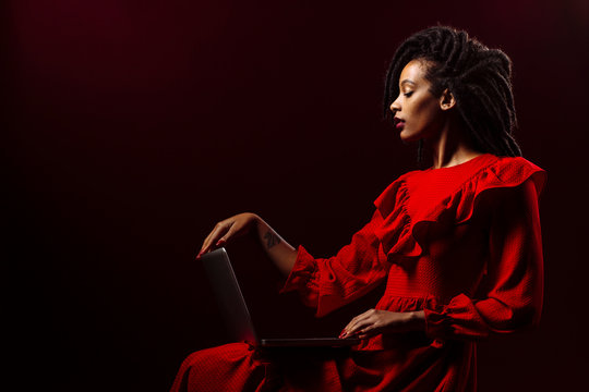 Profile portrait of a woman in red working on her computer
