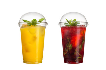 Delicious fruit smoothies in plastic cups, on a white background. Two cocktails with pineapple flavor and berry mojito.