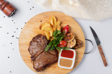 fried meat with french fries and ketchup on round board, top view