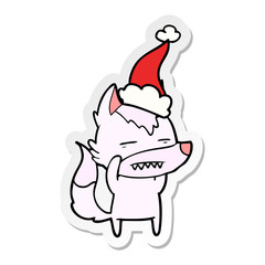 sticker cartoon of a wolf showing teeth wearing santa hat