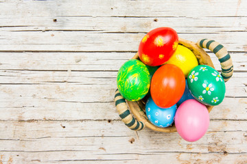 Easter background with handmade colored eggs on nest. Top view and copy space. Festive tradition