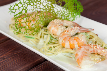  large and appetizing ready-made shrimps beautifully laid out with greens and vegetables for design solutions in cooking