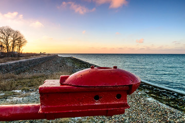 Hel (Poland) - smal town located on Hel Peninsula. Shore at sunset with element of barrier on first plan.