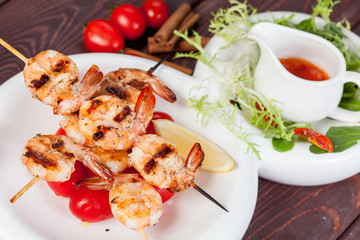  large and appetizing ready-made shrimps beautifully laid out with greens and vegetables for design solutions in cooking