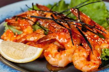  large and appetizing ready-made shrimps beautifully laid out with greens and vegetables for design solutions in cooking
