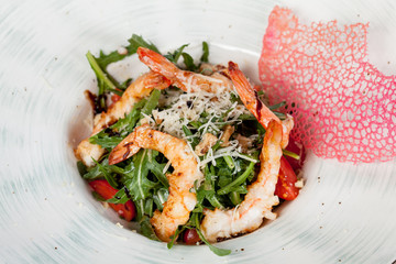  large and appetizing ready-made shrimps beautifully laid out with greens and vegetables for design solutions in cooking