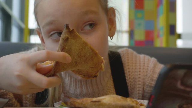 Time to eat! Cute little girl with pizza. Happy child having fun eating dinner. Food concept. Close uo teenager girl face
