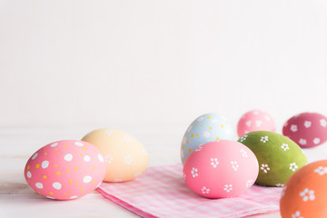 Fototapeta na wymiar Happy easter! Colorful of Easter eggs with pink and white cheesecloth on wooden background.