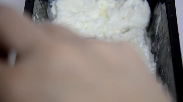 Vanilla ice cream Flat lay. Top view. Spoon for ice cream takes a little out of the package. Macking ball of ice cream.