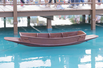 fake ancient Thai wooden boat on blue lake.