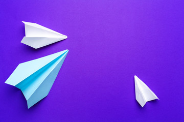 white paper airplane on a purple background