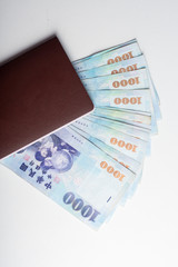 Passport and 1000 New Taiwan Dollar bill on white background
