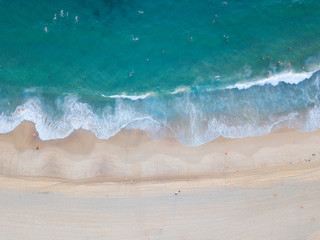 Aerial view of beach shore with clear water in a summer day.