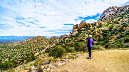 Senior woman hiker enjoying the view of the Valley of the Sun and the McDowell Mountain Range...