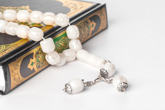 Islamic Book Holy Quran and beads on withe background