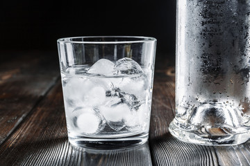 Vodka in shot glasses on rustic wood background