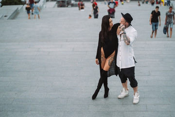 Obraz premium A young, sexy couple of lovers pose for a camera on the streets