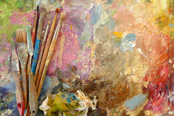 old art brushes on a palette with paints. top view. copy space