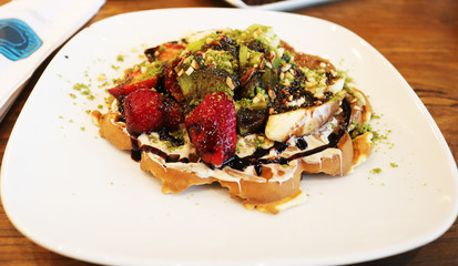 Sweet and delicious waffles with fruits and chocolate syrup 