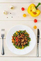 Chicken hearts with green beans on a white wooden table