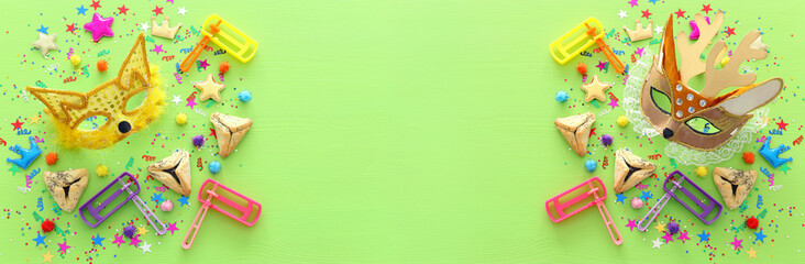 Obraz premium Purim celebration concept (jewish carnival holiday) over wooden green background. banner