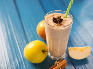 Apple smoothie with cinnamon on wooden table