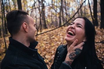 Fototapeta premium portrait of a young woman and a man walking in the autumn forest