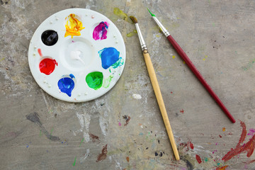 Paintbrush and watercolor paint, palettes on the table smear the color,education and art object,top...