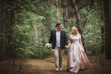 Naklejka na ściany i meble bride and groom kissing in the summer forest