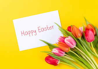 colorful tulips on a yellow background and text happy easter