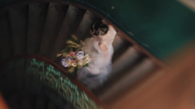 beautiful and young woman coming down the wooden stairs