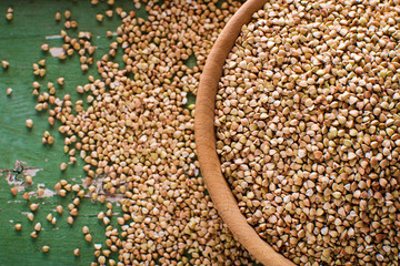 Buckwheat in a wooden bowl on a wooden table, closeup view