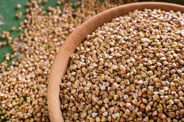 Buckwheat in a wooden bowl on a wooden table, selective focus