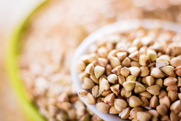 raw green buckwheat in a spoon macro, selective focus