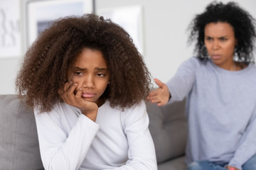 Angry african mother accusing scolding teen daughter