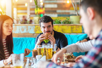 Young friends enjoying dinner at fast food restaurant