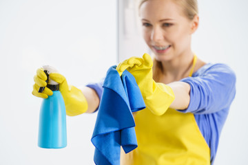 Woman cleaning window at home