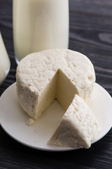 milk on dark table and homemade cheese, cottage cheese