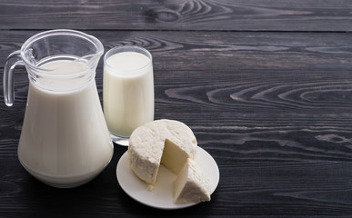 milk on dark table and homemade cheese, cottage cheese