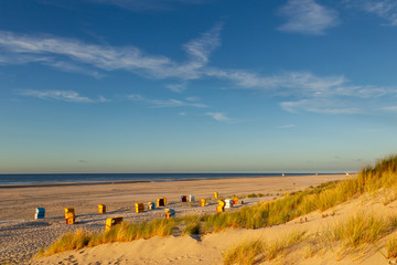 Beach and beach chairs on the East Frisian Island Juist in the North Sea, Germany, in evening light...