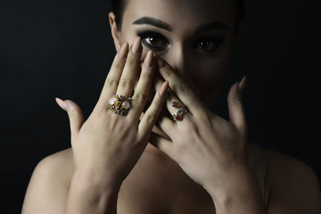 Beautiful girl model shows hands with jewelry. Close up. Beautiful eye. Brunette.