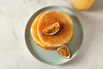 Tasty pancakes with passion fruit on light table