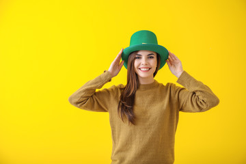 Beautiful young woman in green hat on color background. St. Patrick's Day celebration