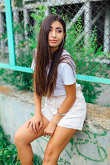 Portrait of a swag girl sitting next to rabitz fence