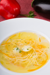 Yellow noodle soup served with quail egg in white plate