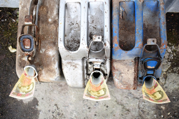 Three metal barrels and Ukrainian money, the concept of the cost of gasoline, diesel, gas. Refueling machines. Banknote 100 hryvnia.