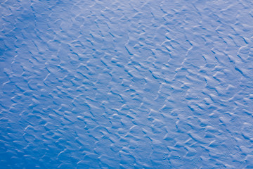 High angle aerial view of abstract snow texture background with rough surface in a blue tones