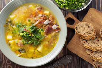 Delicious yellow split peas soup with smoked pork ribs  on a wooden table. Top view