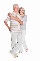 Portrait of senior couple hugging on white background, full length